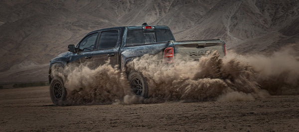 Rear view of a black Ram 1500 RHO off-roading and upgraded with a MagnaFlow Cat-Back exhaust system for enhanced performance and deep signature sound.