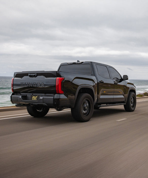 Rear view of a black Toyota Tundra TRD upgraded with a MagnaFlow Cat-Back exhaust system for enhanced performance and deep signature sound.
